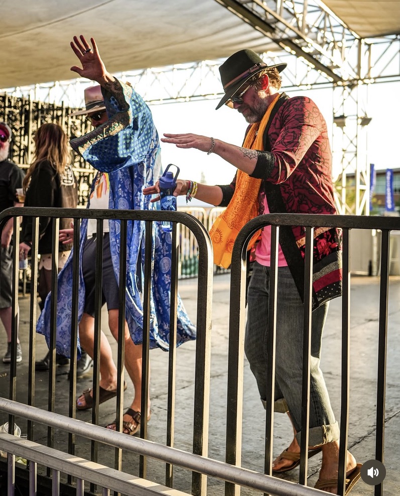 Michael and Doug dancing in robes and scarves at an outdoor festival