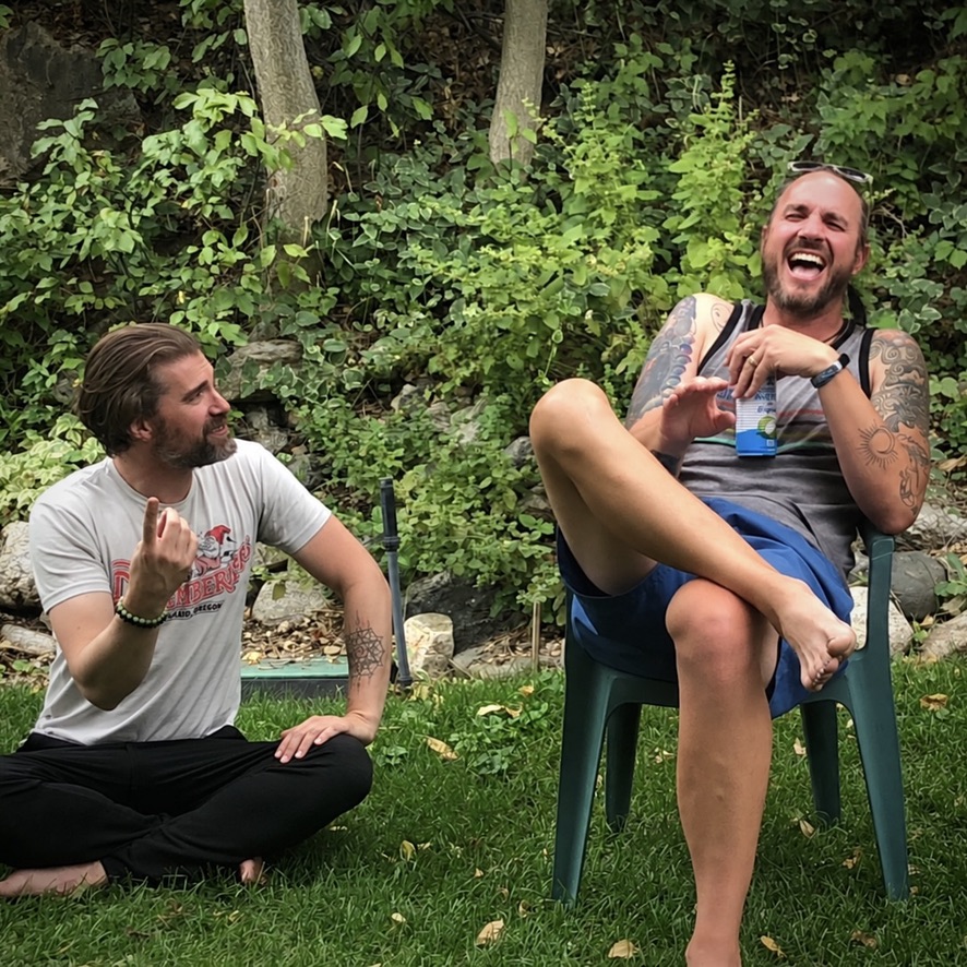 Michael and Doug laughing outdoors on a lawn